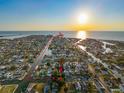 Aerial view of a waterfront community with canal access and a sunset view on the horizon at 13912 Sommers Ave, Hudson, FL 34667