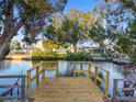 Wooden dock overlooking calm canal waters surrounded by lush greenery and neighborhood homes at 13912 Sommers Ave, Hudson, FL 34667