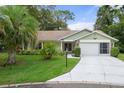 House exterior featuring a two-car garage and lush landscaping at 2241 Merion Ct, Spring Hill, FL 34606