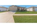 Front view of a single-story house with a driveway and lawn at 12931 Conquistador Loop, Spring Hill, FL 34610