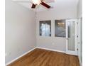 Comfortable bedroom with hardwood floors, a ceiling fan, and french doors leading to another room at 2529 Sandy Hill Ct, Holiday, FL 34691