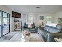 Bright living room features tile floors, cozy seating, and sliding glass doors to outdoor space at 3178 Sea Grape Dr, Hernando Beach, FL 34607
