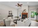 Spacious living room with a fireplace and light hardwood floors at 27949 Ravens Brook Rd, Wesley Chapel, FL 33544