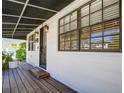 Quaint front porch with a dark wooden deck and black door at 3912 W San Pedro St, Tampa, FL 33629