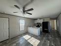 Open living room and kitchen with vinyl flooring and ceiling fan at 1925 Patriot Ln, Holiday, FL 34690