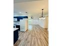 Kitchen boasts dark blue cabinets, white appliances, and wood-look floors at 27173 Simona Ave, Brooksville, FL 34602
