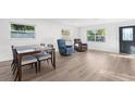 Light-filled living room featuring hardwood floors, dining table, and armchairs at 1718 Montana Ne Ave, St Petersburg, FL 33703