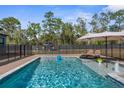 Sparkling in-ground pool with lounge chairs and a secure safety fence at 7376 Fall St, Brooksville, FL 34613