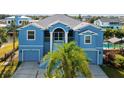 Two-story waterfront home with double garage and palm trees at 7516 Gulf Way, Hudson, FL 34667