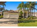 Spacious home exterior with a three-car garage and beautifully landscaped yard at 13235 Legends Trl, Dade City, FL 33525