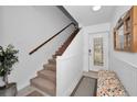 Bright entryway with staircase, bench, and white wainscoting at 1545 Citrine Trl, Tarpon Springs, FL 34689