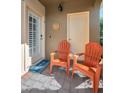 Inviting patio with two orange chairs and a sun-themed decoration at 1545 Citrine Trl, Tarpon Springs, FL 34689
