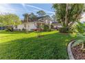 Landscaped backyard with lush grass and mature trees at 2476 Silkwood Ct, Spring Hill, FL 34606