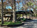 Covered workshop area with a riding lawnmower and storage at 3234 Ella Ln, New Port Richey, FL 34655
