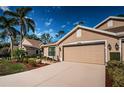 Tan house with two-car garage and landscaping at 9609 Brookdale Dr, New Port Richey, FL 34655