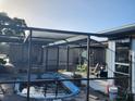 Above-ground pool with a screened enclosure at 1050 Tamarac Dr, Holiday, FL 34690
