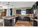 U-shaped kitchen with dark cabinets, granite countertops, and stainless steel appliances at 10724 Burning Bush Ter, Land O Lakes, FL 34638
