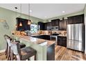 U-shaped kitchen with dark cabinets, granite countertops, and stainless steel appliances at 10724 Burning Bush Ter, Land O Lakes, FL 34638