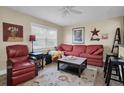 Cozy living room with red couch, wood floors, and a large window at 11617 Boynton Ln, New Port Richey, FL 34654