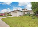 House exterior featuring a garage and manicured lawn at 13455 Niti Dr, Hudson, FL 34669