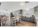 Modern kitchen with gray cabinets, island, and stainless steel appliances at 13822 Judy Ave, Hudson, FL 34667