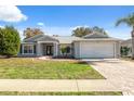 One-story house featuring gray exterior, a two-car garage, and well-maintained lawn at 3470 Cedar Crest Loop, Spring Hill, FL 34609