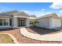 House exterior showcasing a walkway, gray siding, and a two-car garage at 3470 Cedar Crest Loop, Spring Hill, FL 34609