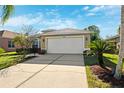 Front view of a tan house with a white garage door at 4886 Westchester Ct, Oldsmar, FL 34677