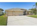 Three-car garage and attractive landscaping enhance this home's curb appeal at 7302 Melogold Cir, Land O Lakes, FL 34637