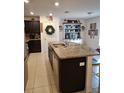 Modern kitchen with dark cabinets, granite countertops, and a large island at 8278 Silverbell Loop, Brooksville, FL 34613