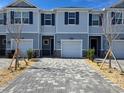 Two-story townhome with gray exterior, two-car garage, and landscaped front yard at 12466 Amber Creek Cir, Lakewood Ranch, FL 34211