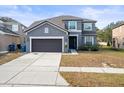 Two-story house with gray exterior, brown garage door, and landscaping at 14143 Wake Robin Dr, Brooksville, FL 34604