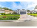 Tan one-story house with a two-car garage and nicely landscaped yard at 262 Hartford Ct, Spring Hill, FL 34609
