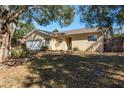 Front view of a tan house with a white garage door at 29703 69Th N St, Clearwater, FL 33761