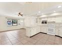 Kitchen boasts white cabinets, tile floors, and modern appliances at 5461 Colchester Ave, Spring Hill, FL 34608