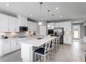 Modern kitchen with white cabinets, large island, and stainless steel appliances at 10017 Zennia Ln, Parrish, FL 34219