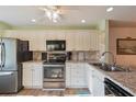Bright kitchen featuring granite countertops and modern appliances at 11445 Orleans Ln, Port Richey, FL 34668