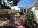 Backyard with patio, wooden chairs, and a screened enclosure at 6422 Tralee Ave, New Port Richey, FL 34653