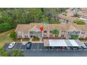 Aerial view of condo building, showing parking and surrounding trees at 6604 Spring Flower Dr # 23, New Port Richey, FL 34653