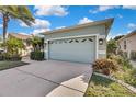 Front view of the house with a light teal two-car garage at 8148 Ambersweet Pl, Land O Lakes, FL 34637