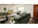 Virtually staged living room featuring green velvet sofas and a large TV at 9321 Mansard Ln, Port Richey, FL 34668