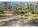 Ranch style home with stone exterior and a large yard at 10417 Joyce Dr, Brooksville, FL 34601