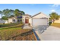 Front view of a single-story house with a two car garage at 10451 Keystone St, Spring Hill, FL 34608