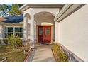 Front door entry with decorative glass and walkway at 10451 Keystone St, Spring Hill, FL 34608