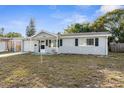 Gray house with a well-maintained lawn, single-car garage, and a spacious front yard at 10841 Gawain Rd, Port Richey, FL 34668