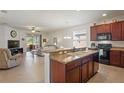 Open kitchen with a breakfast bar, dark wood cabinets, and granite countertops at 11243 Merganser Way, New Port Richey, FL 34654