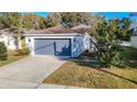 Single story house with gray garage door and small lawn at 14549 Wake Robin Dr, Brooksville, FL 34604