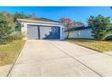 Single-story home with gray garage door and driveway at 14549 Wake Robin Dr, Brooksville, FL 34604