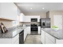 Modern kitchen with white cabinets, granite countertops, and stainless steel appliances at 17104 6Th E Ter, Bradenton, FL 34212