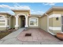 Front entry with a covered patio, columns, and a double door entrance at 3110 Lema Dr, Spring Hill, FL 34609